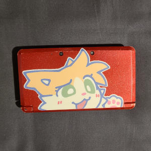 Metallic red rectangle with a sticker of a cartoon cat.