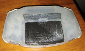 Translucent, light purple, slightly oval-shaped slab with a informational label and a black ridged panel