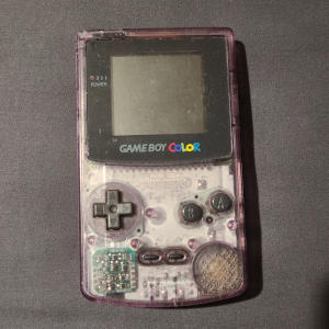A small slab of transparent purple plastic and electronics, with a screen and buttons.