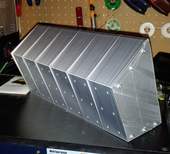 A silver box with fins along the top, and bolts in the side.
