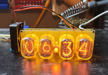 Two stacked circuit boards with the glass tubes on the board in front. Wires run to a small fan set next to the stack.