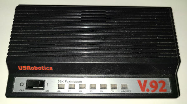 A black plastic slab with a 'console' that projects from the front like a piano keyboard. The console is silver, has rocker switch for power, and seven square indicator lights. The most prominent labels say: 'USRobotics', '56K Faxmodem', and 'v.92'.