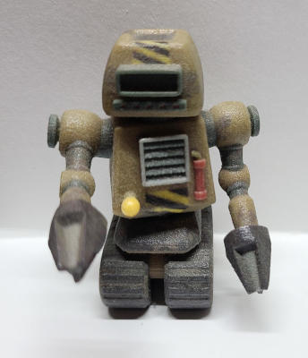 A squat, brown, robot on tank treads. Each arm ends in a conical drill.